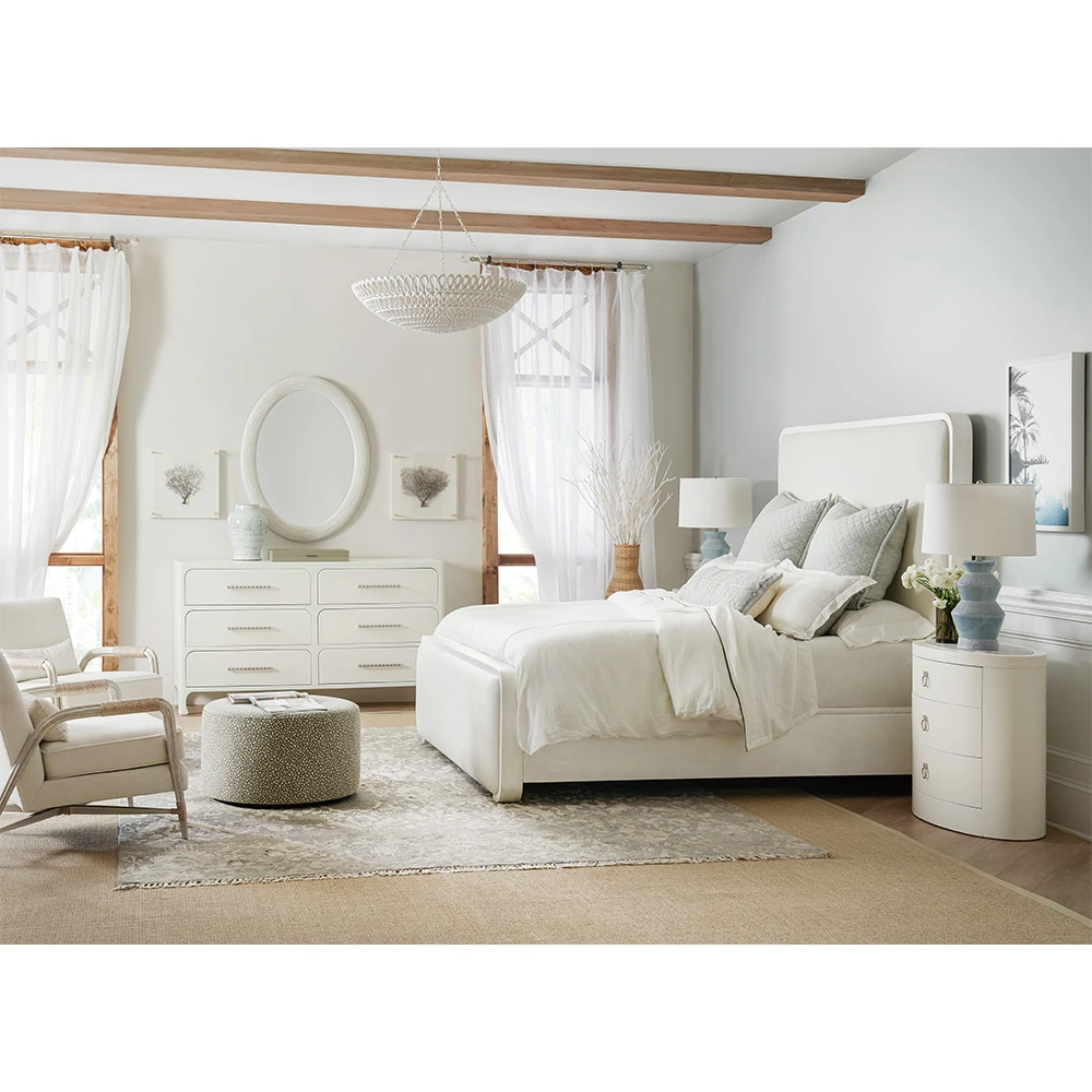 A bedroom with a white dresser, bed, and nightstand from a different angle