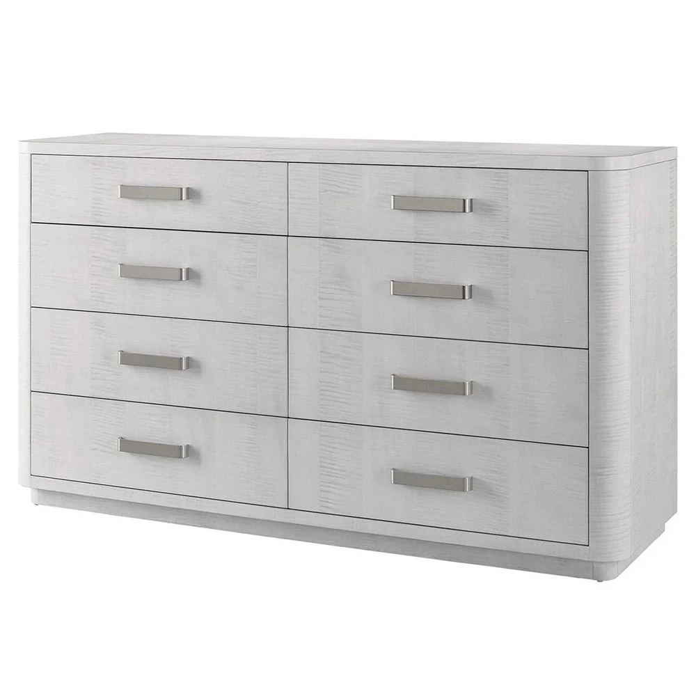 An angled view of a white wooden dresser with eight drawers and silver handles.