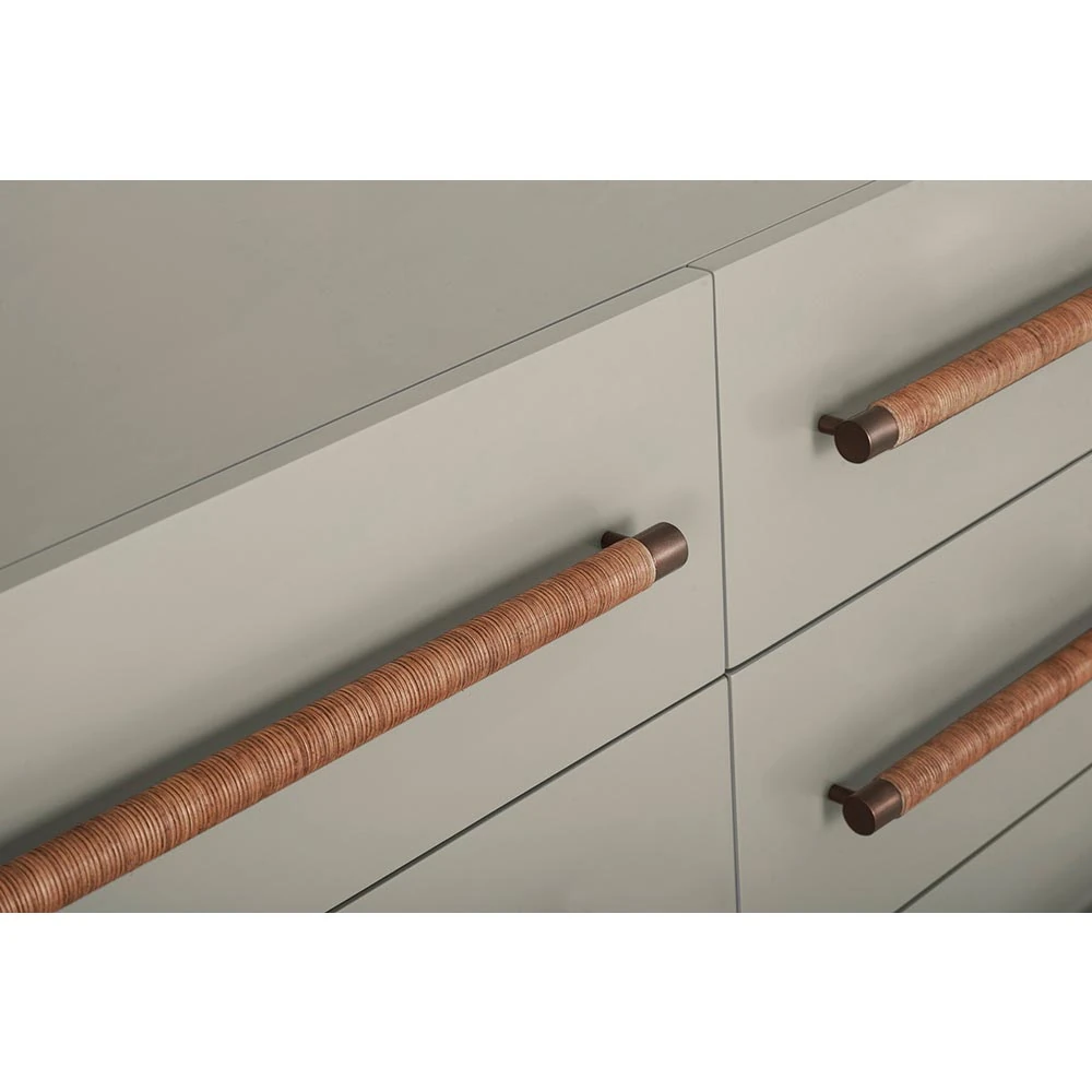 A close-up of the dresser's drawers and wooden handles.