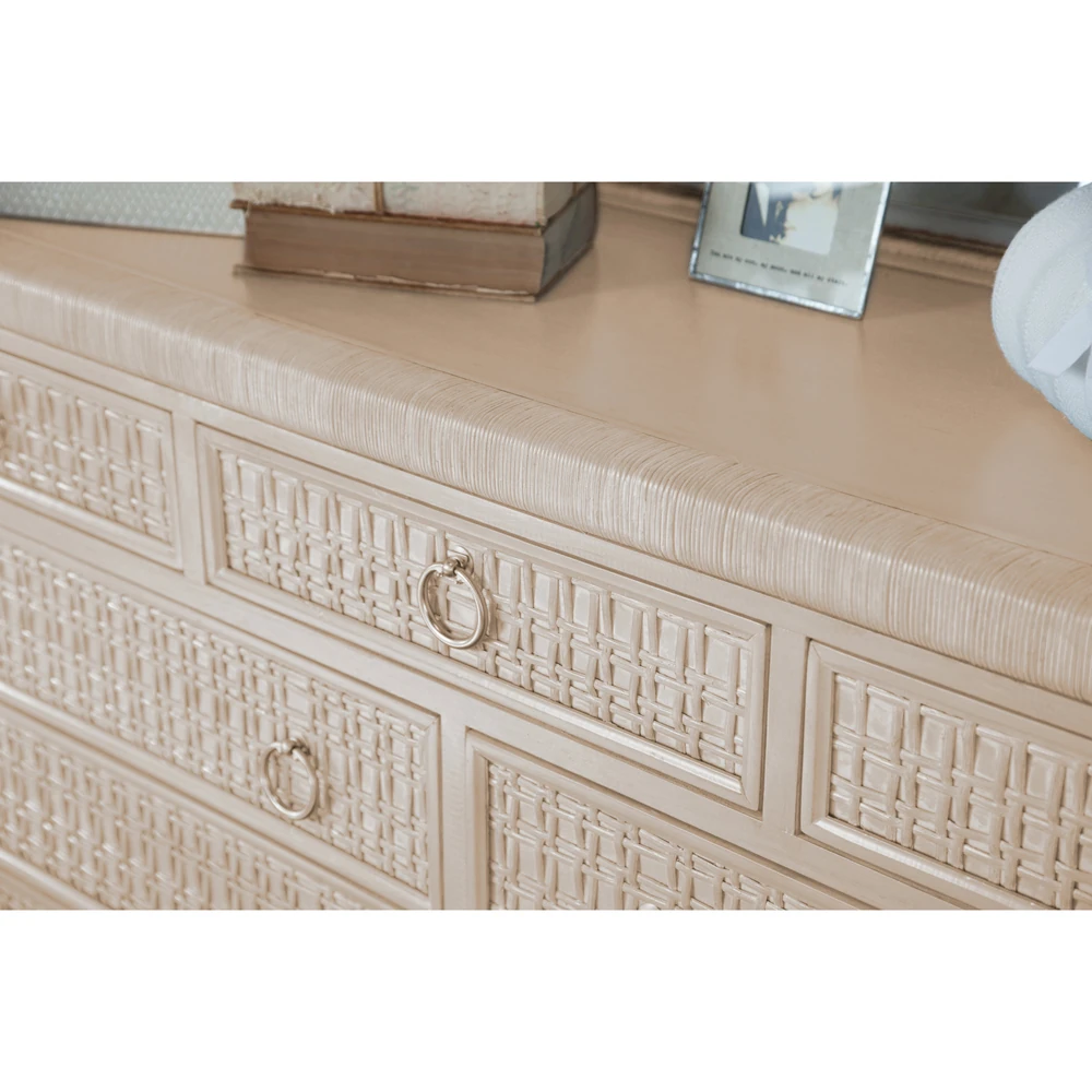 A close-up of a beige dresser's drawers and woven pattern.