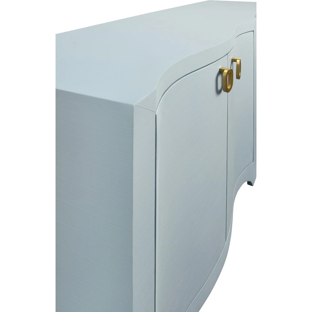 A close-up of the corner of a light blue sideboard with gold handles.