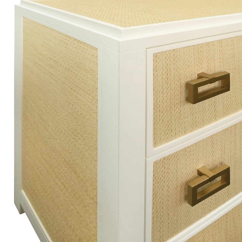 A close-up view of the corner of a dresser with woven drawer fronts and a white frame.