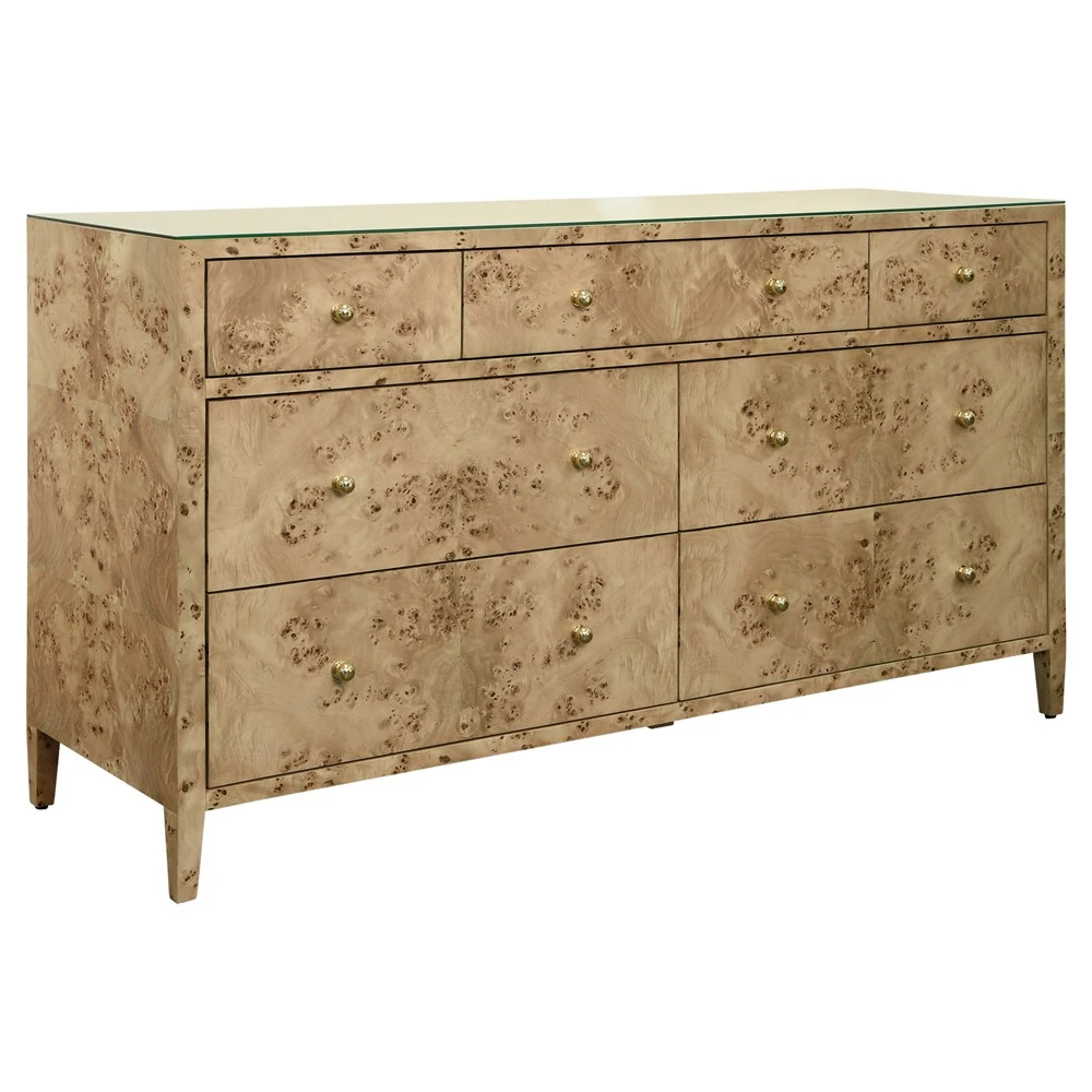 A dresser with a light-colored wood finish and gold knobs, shown from an angle