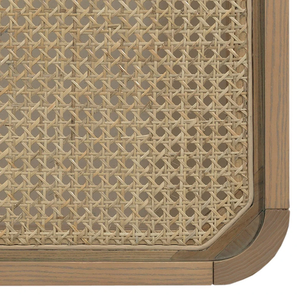 A close-up of a woven rattan table corner with a light brown wooden frame