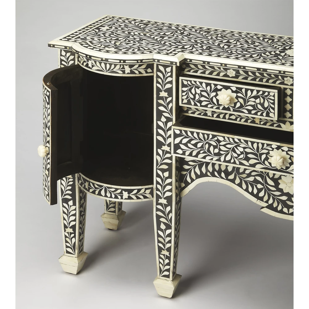 A close-up of a black and white desk with intricate floral designs