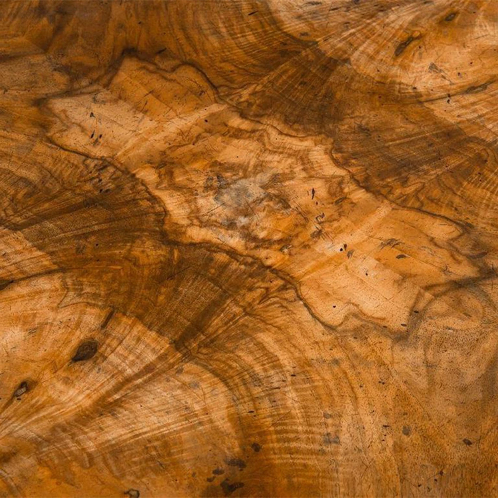 A close-up of a wooden surface with a detailed, multi-tonal wood grain pattern.