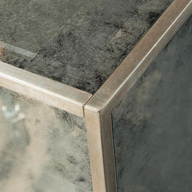 A close-up of the sideboard's corner, showcasing its silver frame.