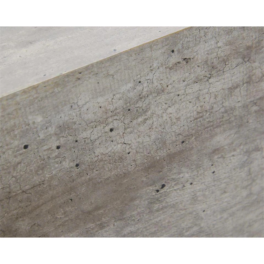 A close-up of the concrete surface of the coffee table, showing its texture and small holes.