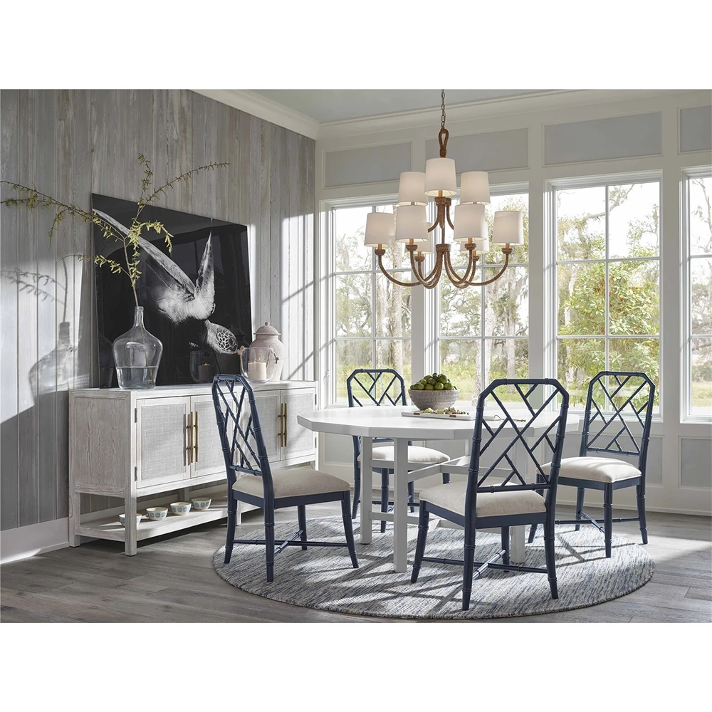 Dining room with light-colored wooden sideboard, white table, and blue chairs