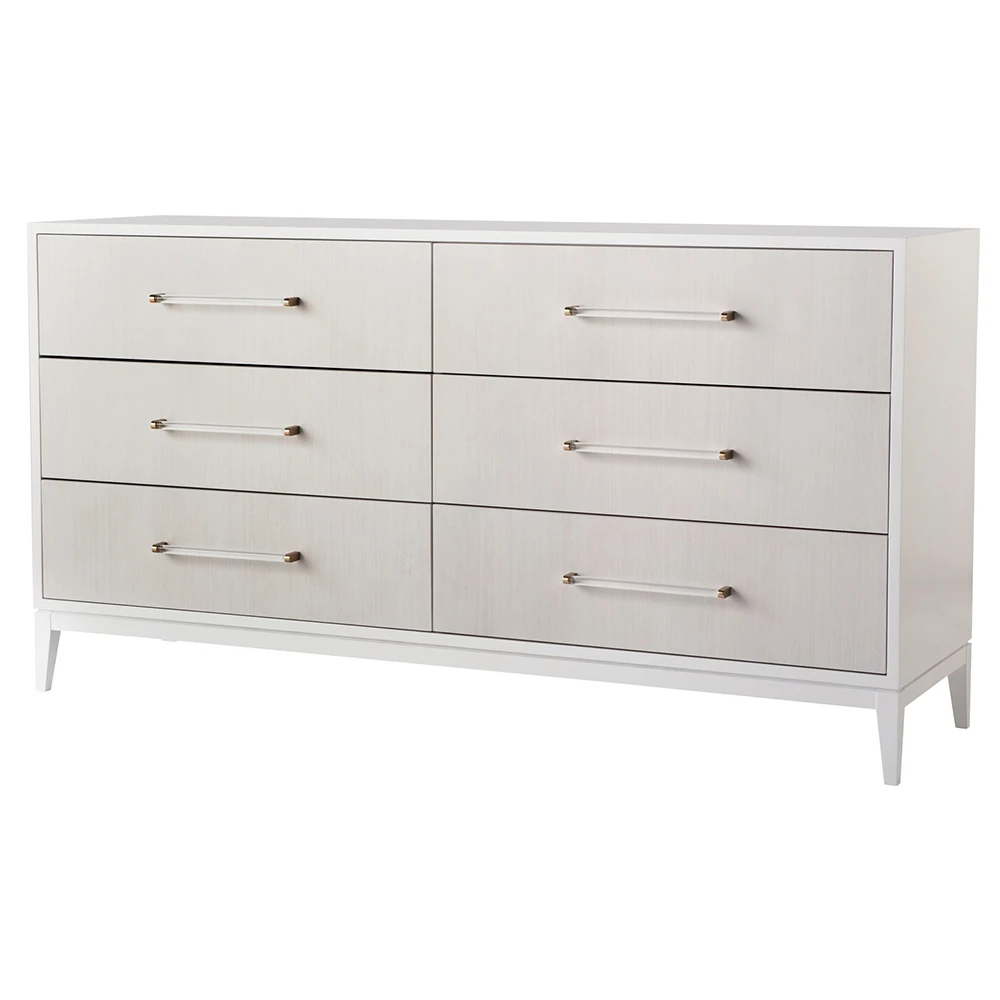 A white dresser with six drawers and gold handles, viewed from an angle.