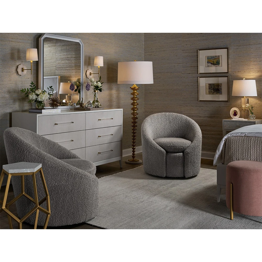 A bedroom with a white dresser, mirror, and gray chairs.
