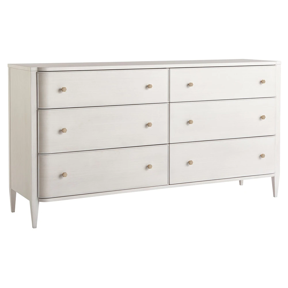 A white dresser with six drawers and gold knobs, viewed at an angle.