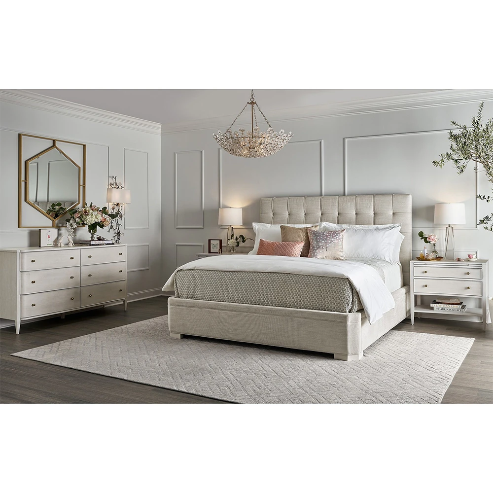 A bedroom with a white dresser, bed, and other furniture.